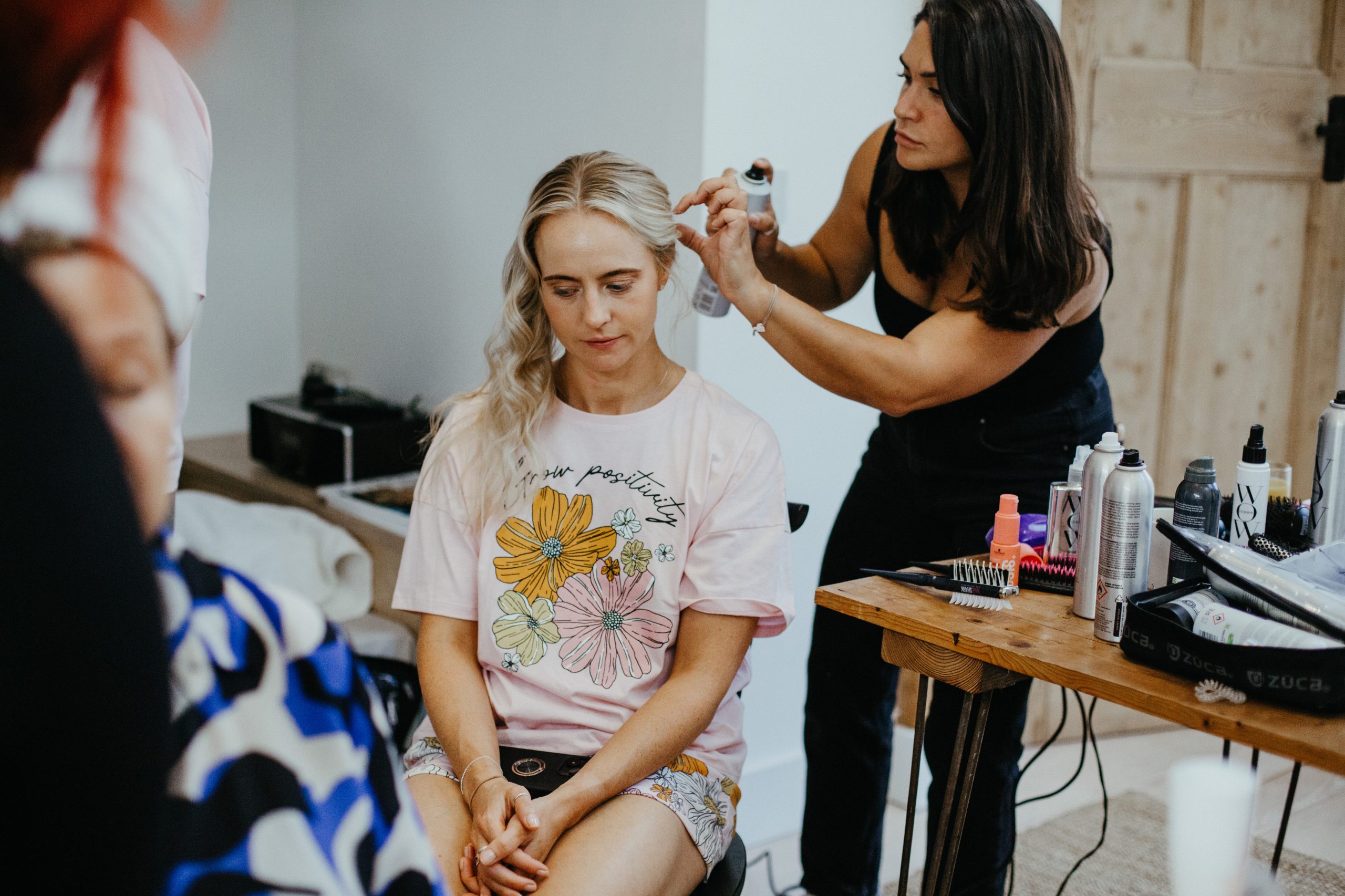 Amelia Carmela styling blonde bridesmaid hair at a wedding 