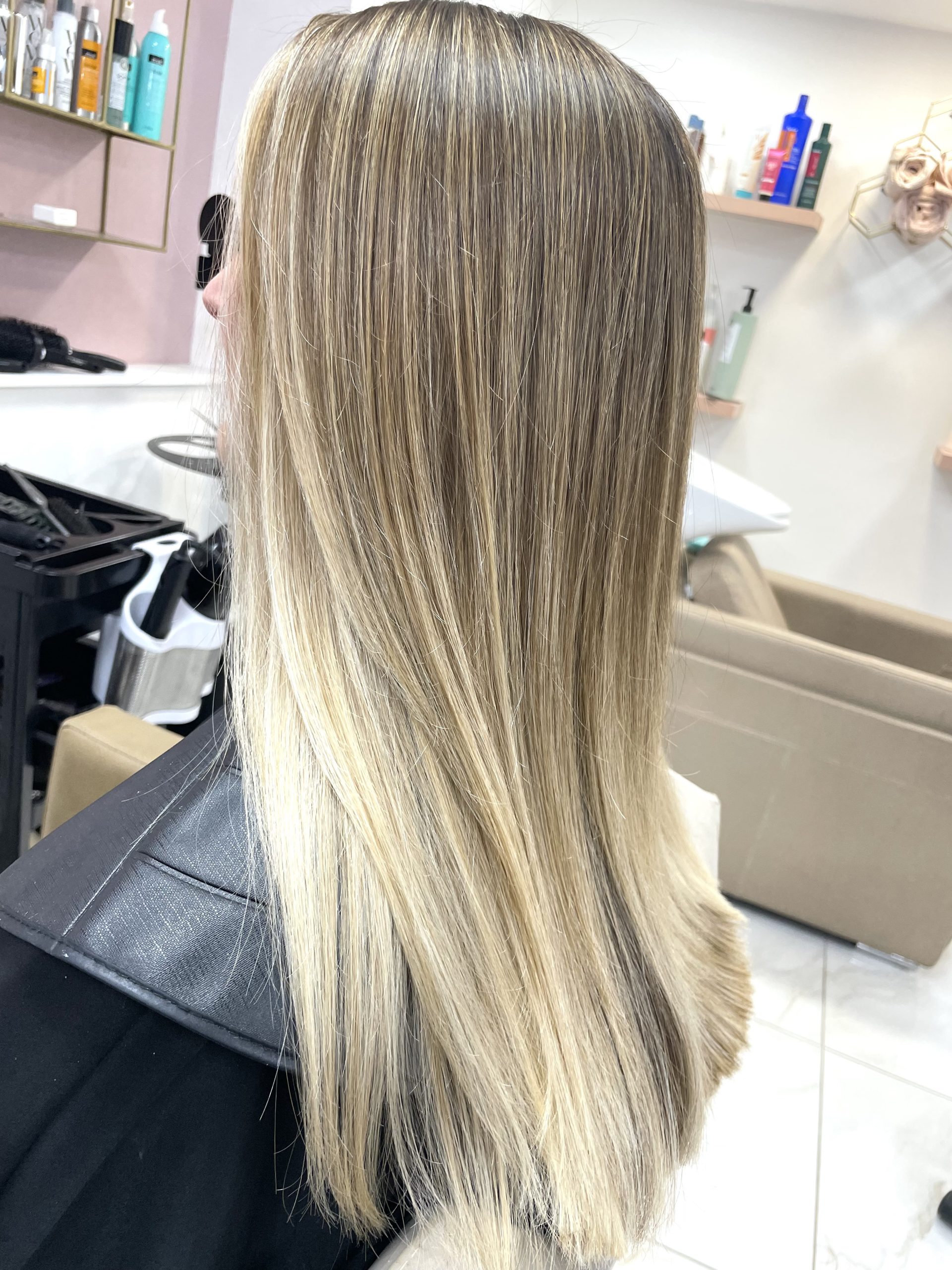 woman with long blonde hair and babylights in hairdresser's chair 